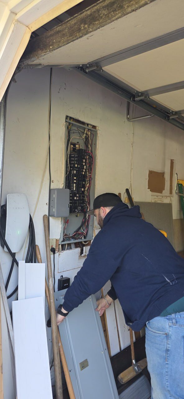 Instructor removing the cover of an electrical panel during a mock home inspection
